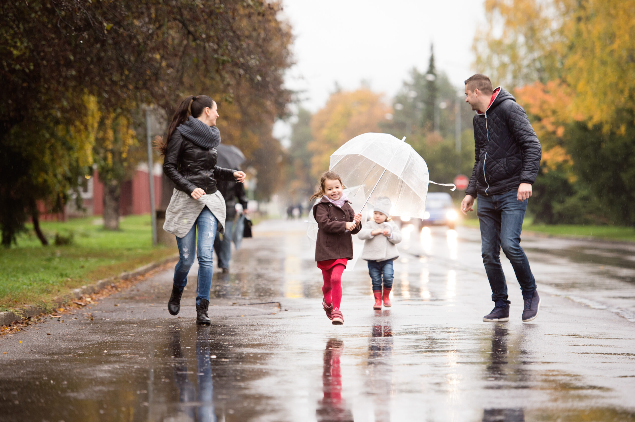 Family strolling together in rainy weather