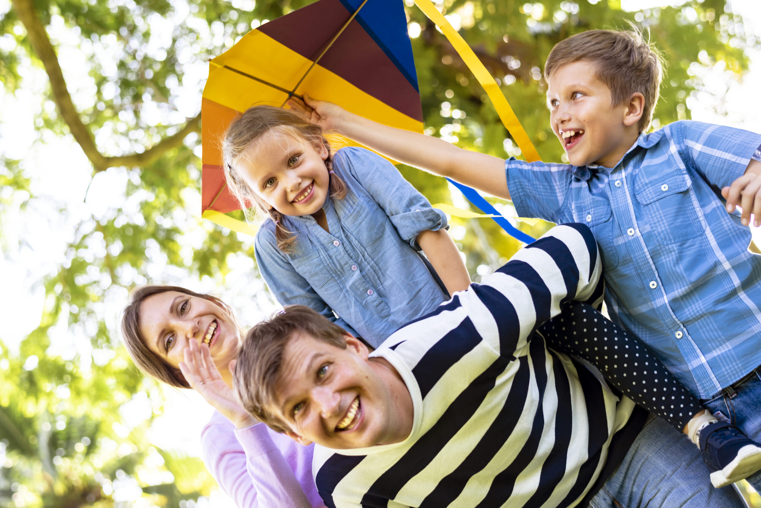Family playing outdoors with a colourful kite