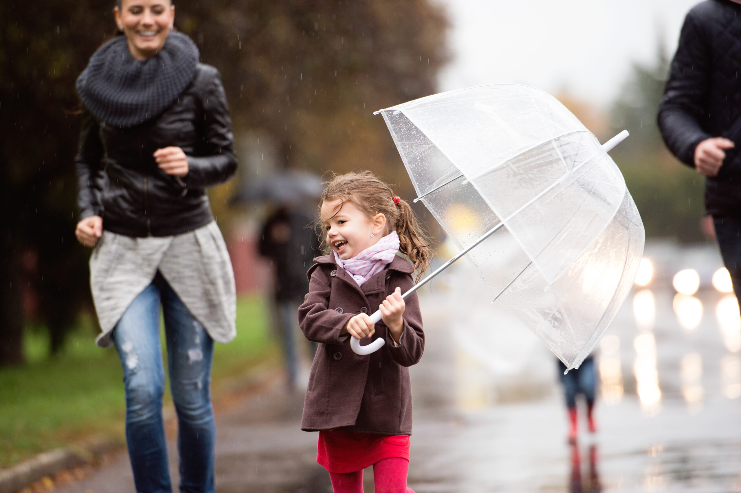 Happy girl walking with her umbrella in the rain