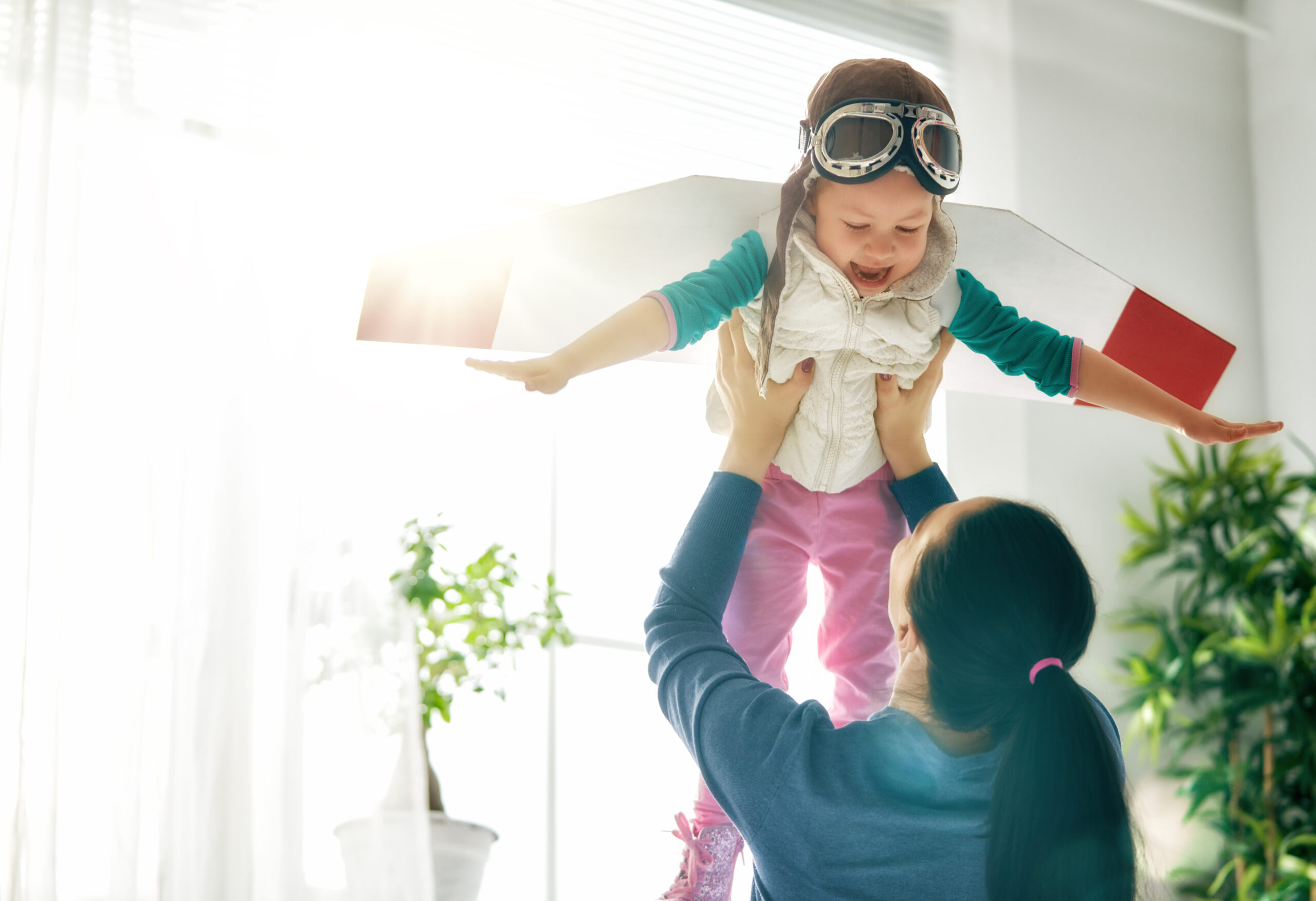 Playful mother and child pretending to fly